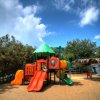 Un'area giochi colorata su sabbia con scivoli.
