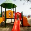Scivolo rosso in un parco giochi su una spiaggia.