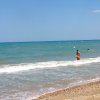 Uomo e bambino camminano nel mare vicino alla riva.