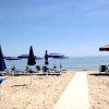 Ombrelloni blu su una spiaggia sabbiosa.