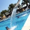 Bambino in piscina con cascata d'acqua.