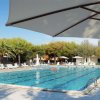 Ampia piscina circondata da sedie a sdraio.