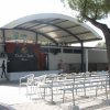 Palco all'aperto con sedie bianche disposte di fronte.