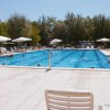 Piscina con lettini e ombrelloni bianchi.