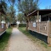 Sentiero tra bungalow in legno e alberi.