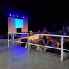 Palco illuminato con persone in attesa.