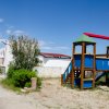 Parco giochi colorato vicino a un edificio bianco.