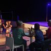 Persone sedute davanti a un palco, guardando bambini ballare.