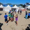 Gruppo di persone che conversano su una spiaggia.