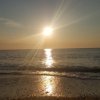 Tramonto sul mare con riflessi sull'acqua.