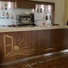 Bar con bancone in legno e mensole con bottiglie.