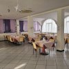 Sala da pranzo con tavoli apparecchiati e finestre ampie.