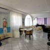 Sala luminosa con arredi moderni, pavimento piastrellato e un murale di una donna sulla spiaggia.