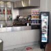 Banco di un bar moderno con scaffali di bibite, macchinetta del caffè e frigorifero per snack.